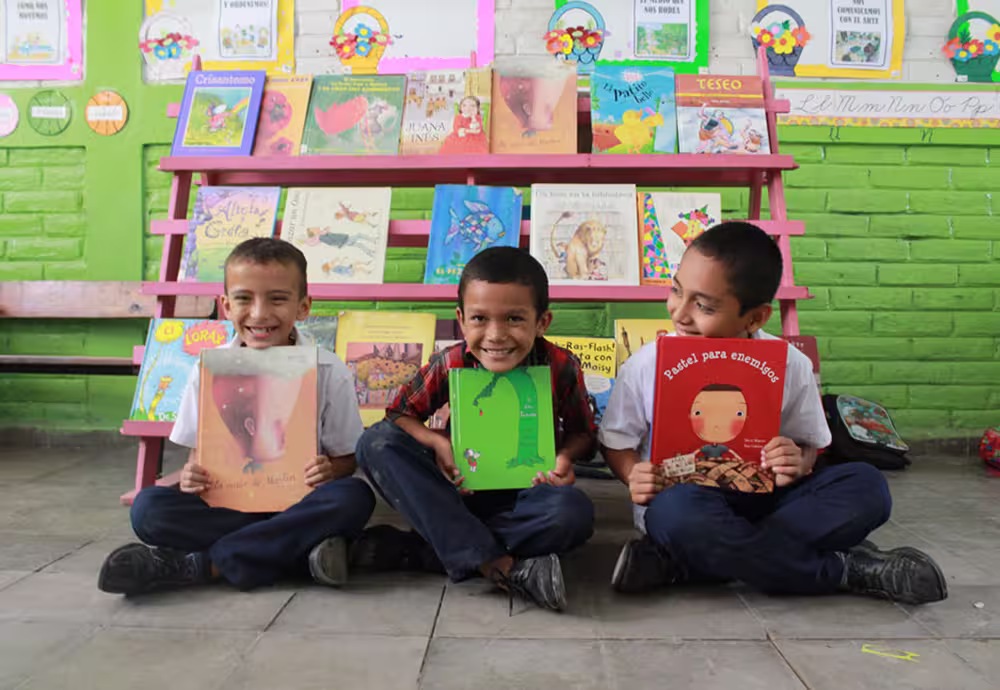 Children smiling hold books